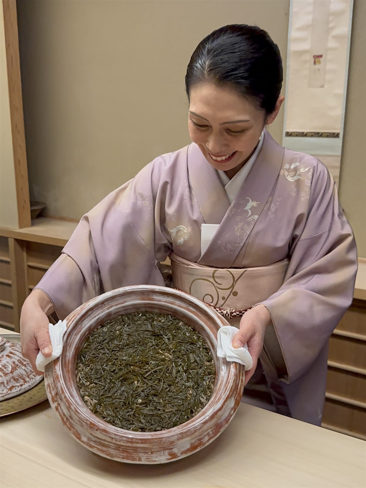 かじめを入れた器を手にする着物姿の女将