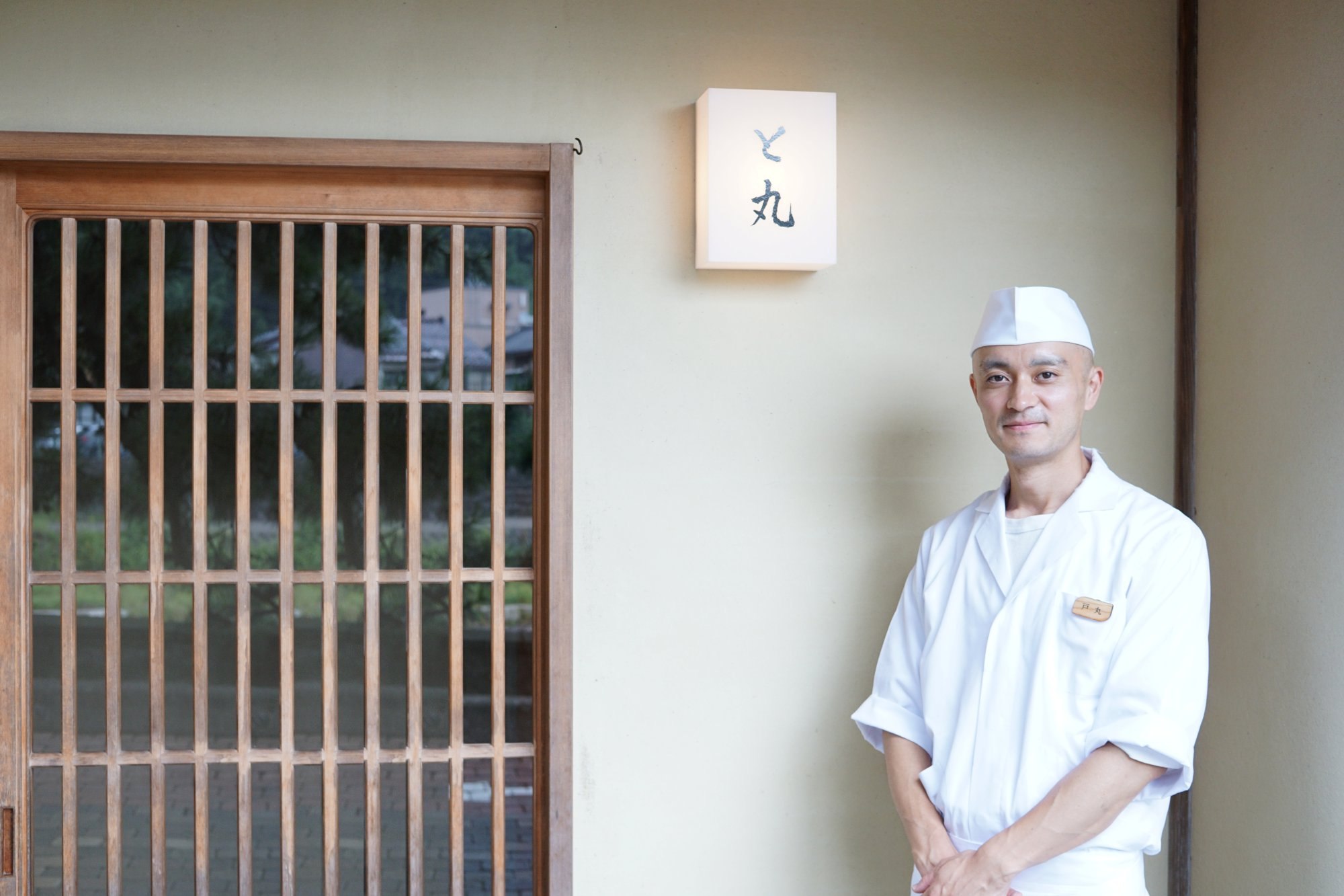 「と丸」の行灯の横に立つ戸丸直貴さん